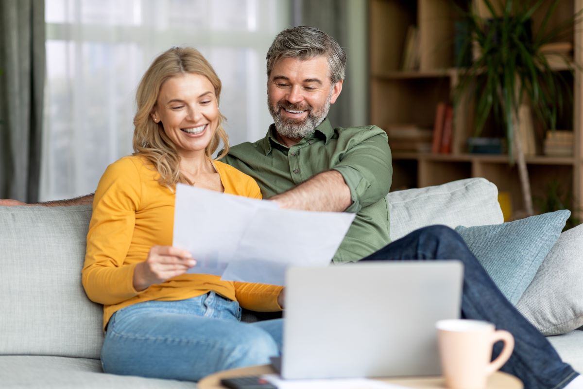 Couple reviewing documents sitting on a couch
